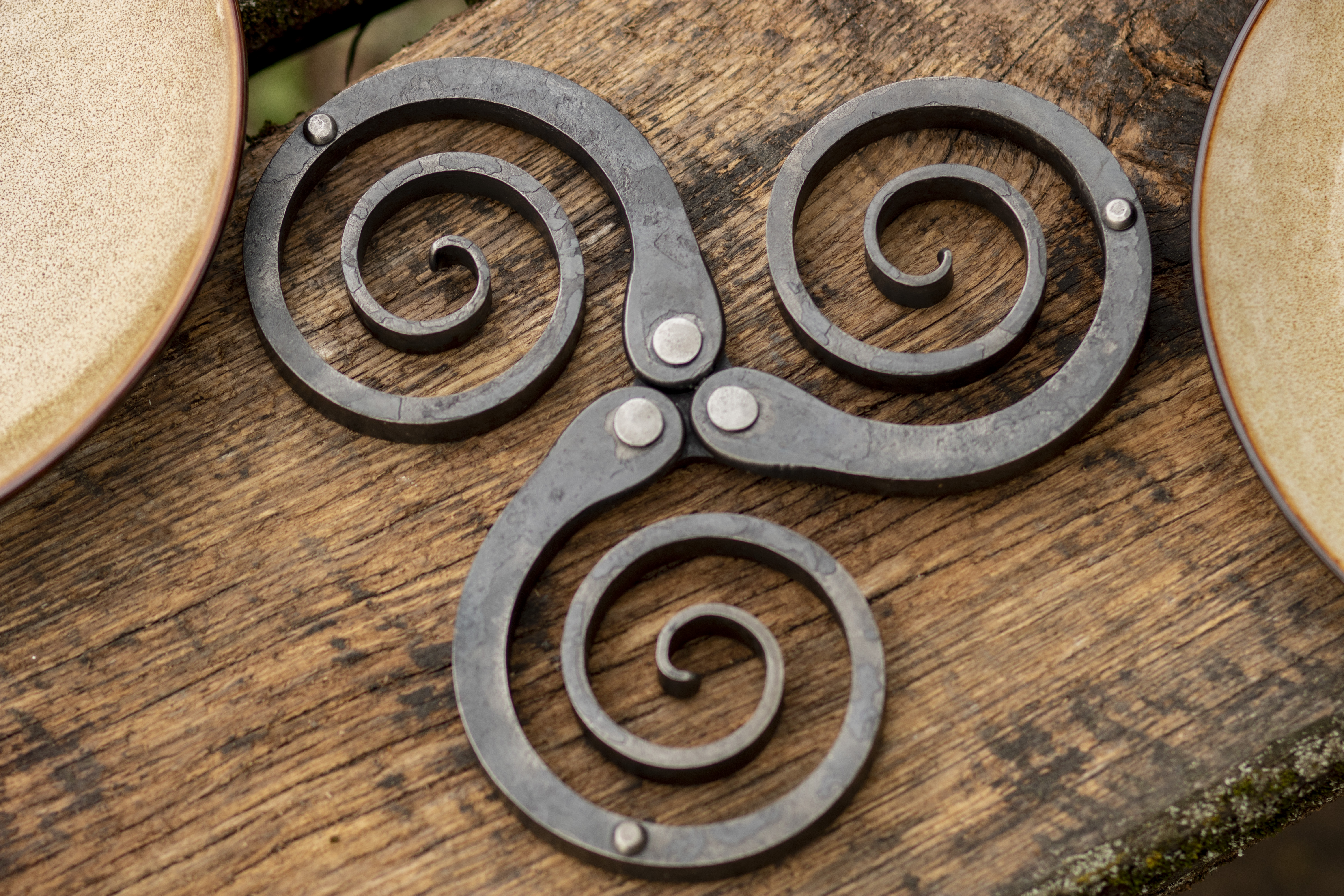 Rustic wrought iron trivet - hand forged metal pot holder and table decor featuring a Celtic triskelion design