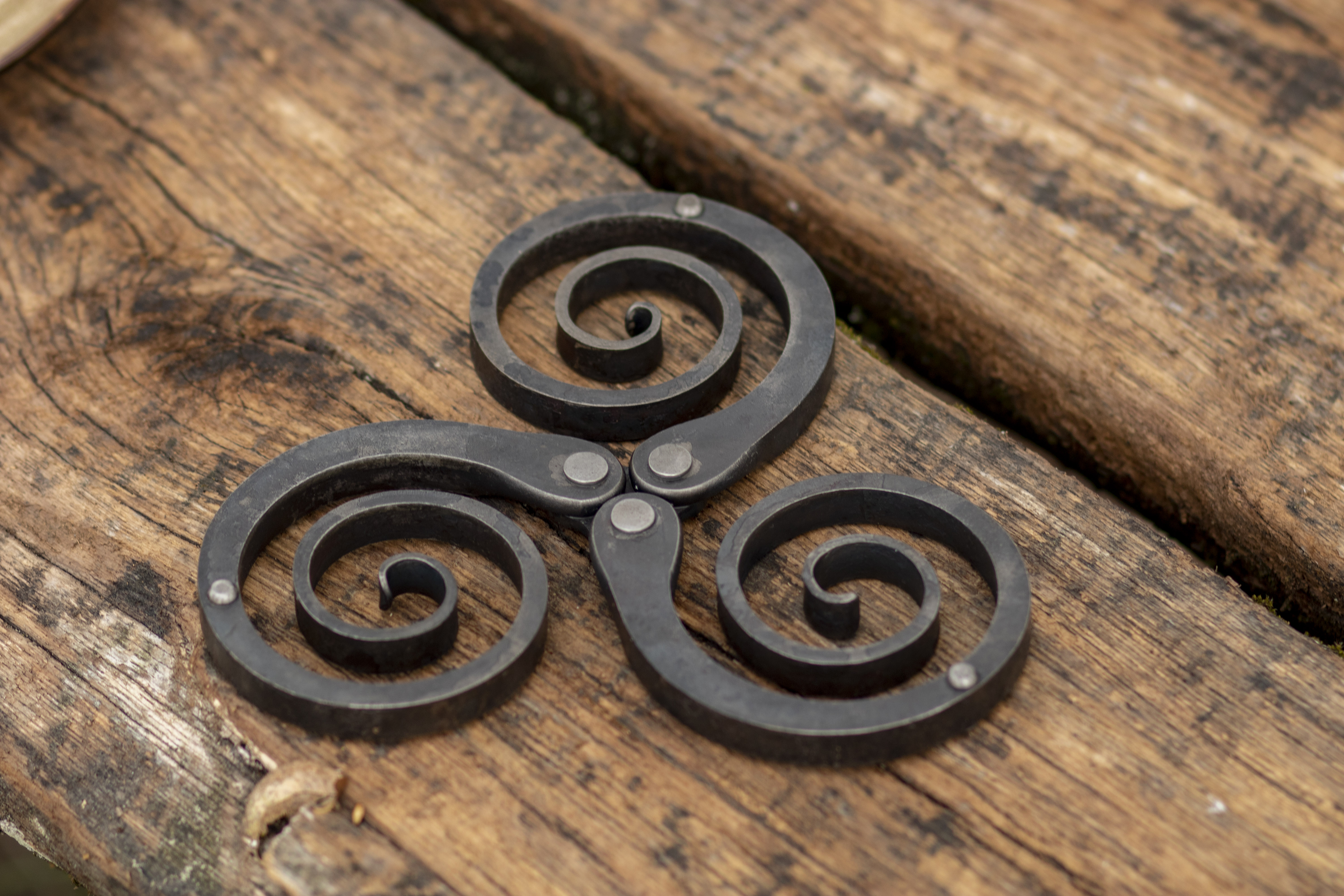 Rustic wrought iron trivet - hand forged metal pot holder and table decor featuring a Celtic triskelion design, photo 4