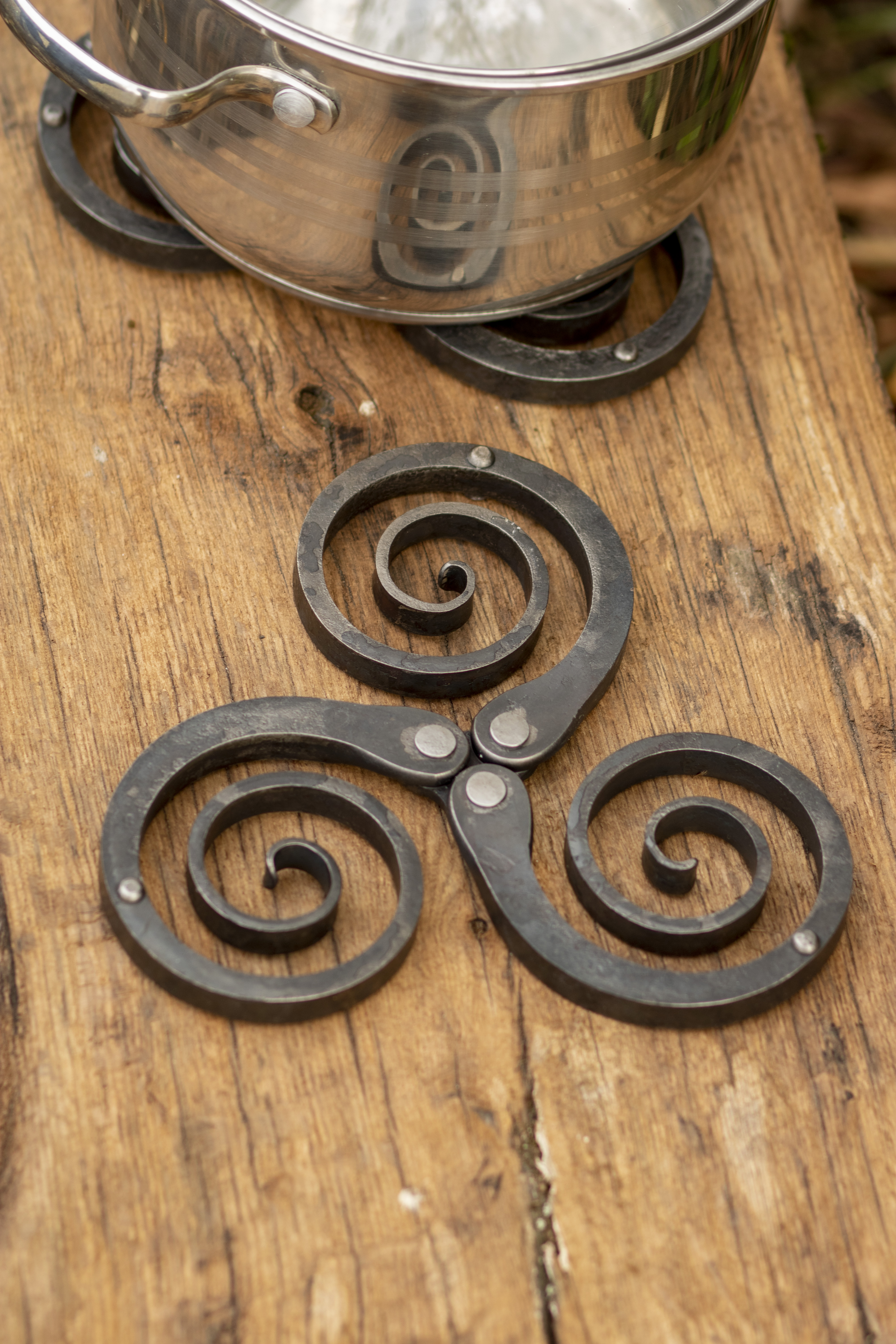 Rustic wrought iron trivet - hand forged metal pot holder and table decor featuring a Celtic triskelion design, photo 6