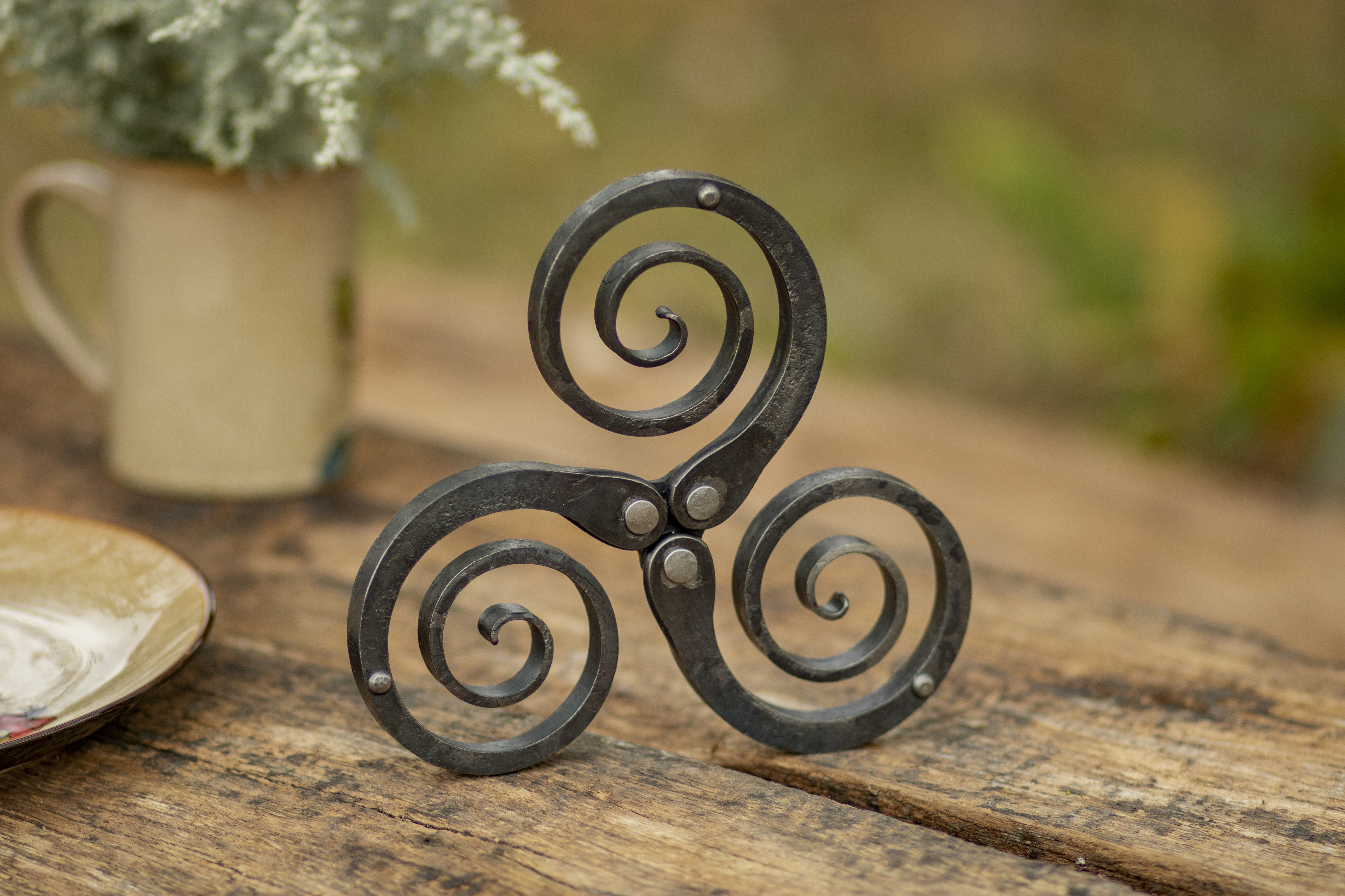 Rustic wrought iron trivet - hand forged metal pot holder and table decor featuring a Celtic triskelion design, photo 3