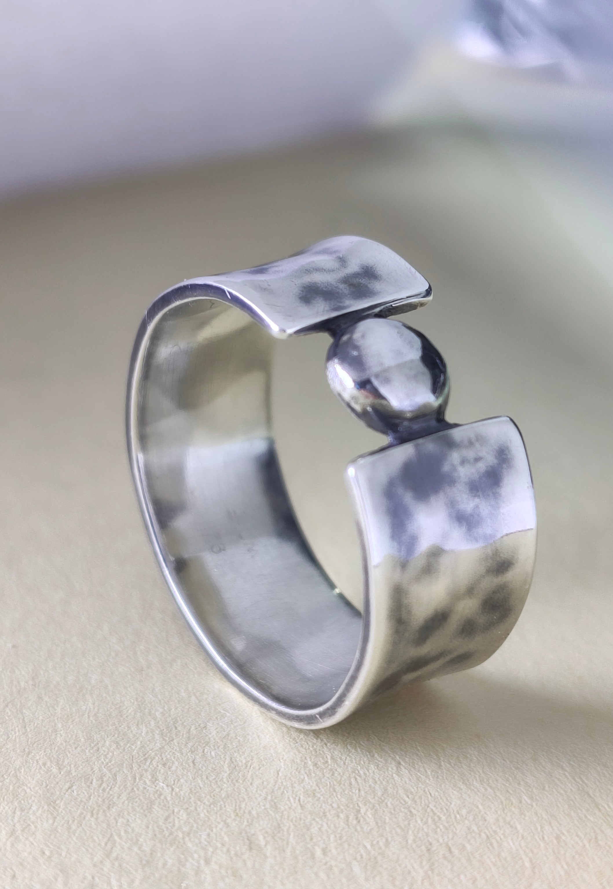 Hand-hammered sterling silver ring with patina and a single sphere set in the opening